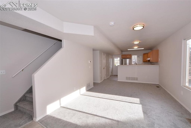 unfurnished living room featuring light colored carpet