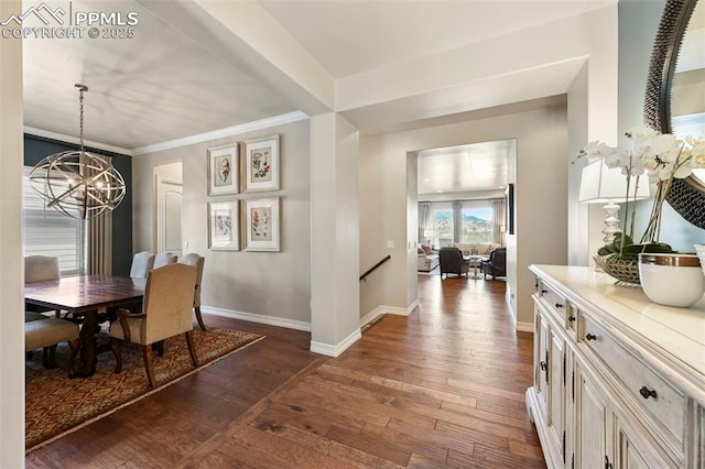 dining space featuring dark hardwood / wood-style flooring, a notable chandelier, and crown molding