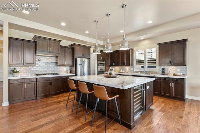 kitchen with a kitchen island, dark hardwood / wood-style floors, decorative light fixtures, a breakfast bar area, and stainless steel appliances