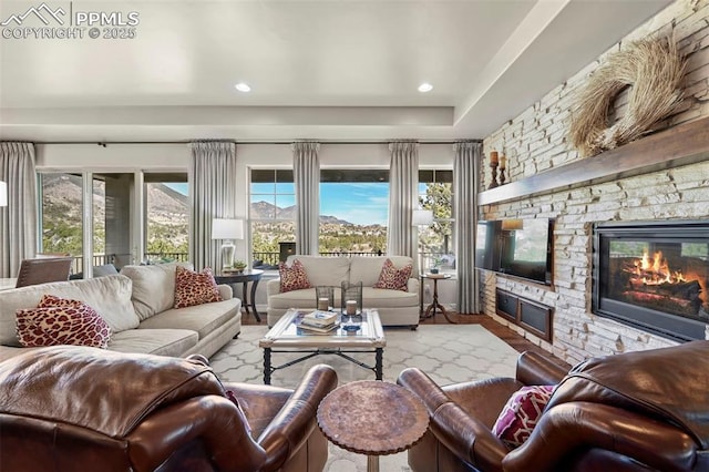 living room with a wealth of natural light, a fireplace, and hardwood / wood-style flooring