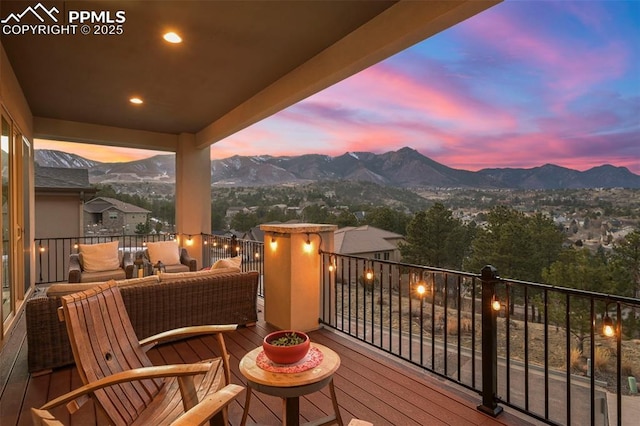 deck at dusk with a mountain view and outdoor lounge area