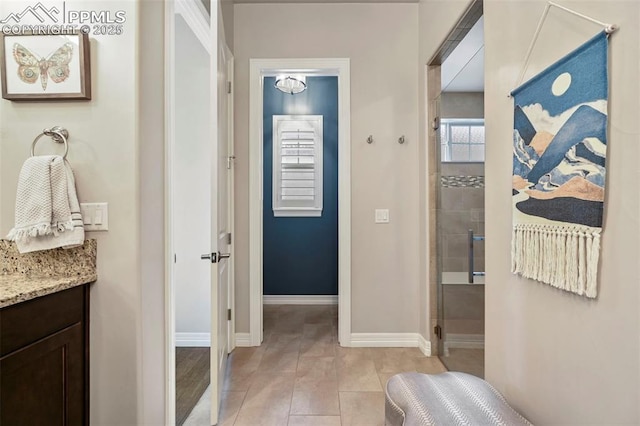 bathroom featuring vanity, a shower with shower door, and tile patterned flooring