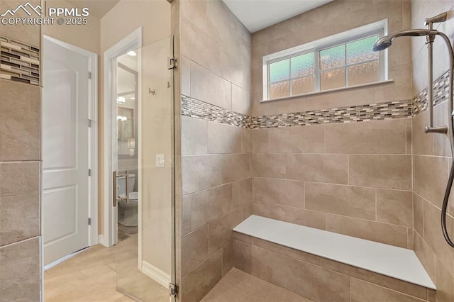 bathroom featuring a tile shower, hardwood / wood-style floors, and toilet