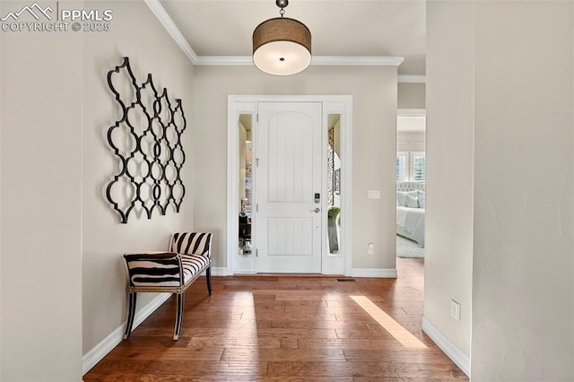 entrance foyer with ornamental molding and hardwood / wood-style floors