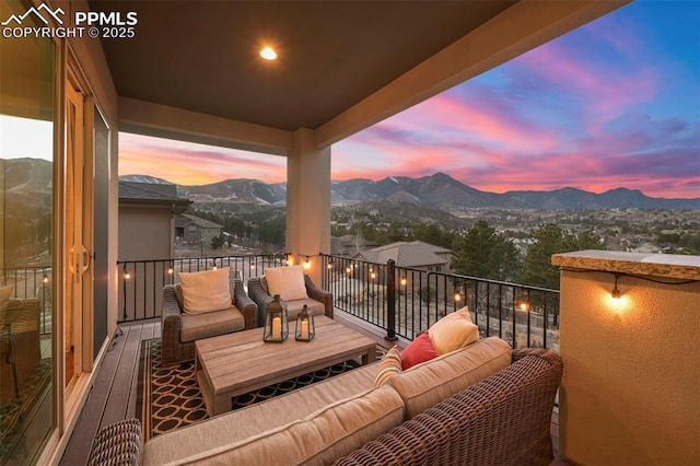 balcony at dusk featuring a mountain view and outdoor lounge area