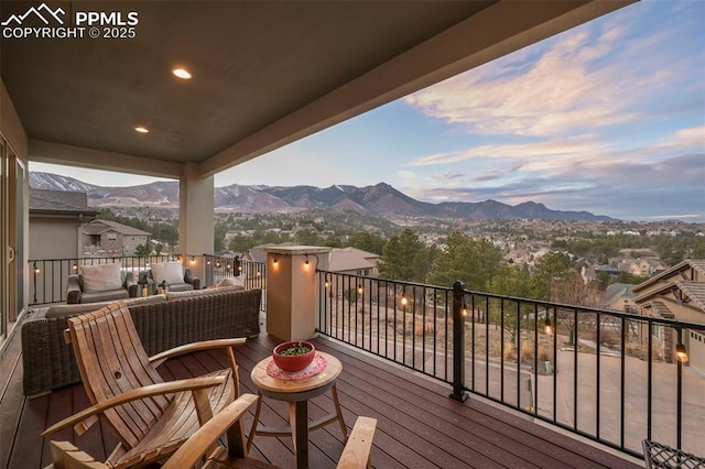 deck at dusk with a mountain view and outdoor lounge area