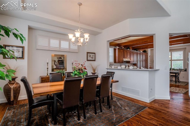 dining space with dark wood-type flooring and a notable chandelier