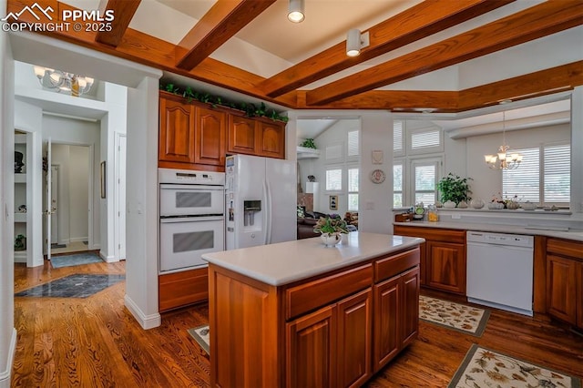 kitchen featuring a chandelier, dark hardwood / wood-style flooring, a kitchen island, white appliances, and beam ceiling