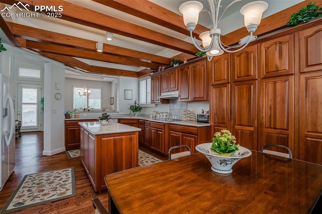 kitchen with decorative light fixtures, dark hardwood / wood-style floors, a kitchen island, a notable chandelier, and beamed ceiling