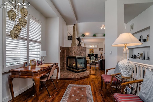 living room with hardwood / wood-style flooring, a multi sided fireplace, and ceiling fan