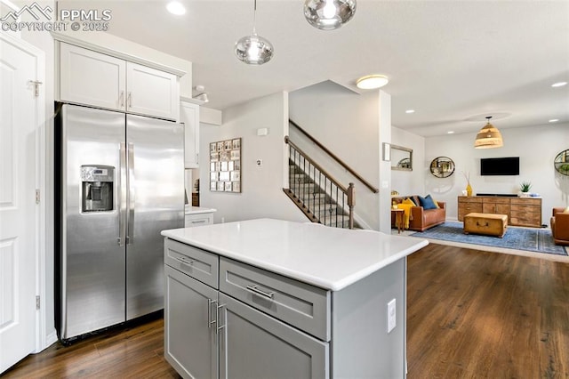 kitchen with a kitchen island, dark hardwood / wood-style floors, pendant lighting, gray cabinetry, and stainless steel refrigerator with ice dispenser