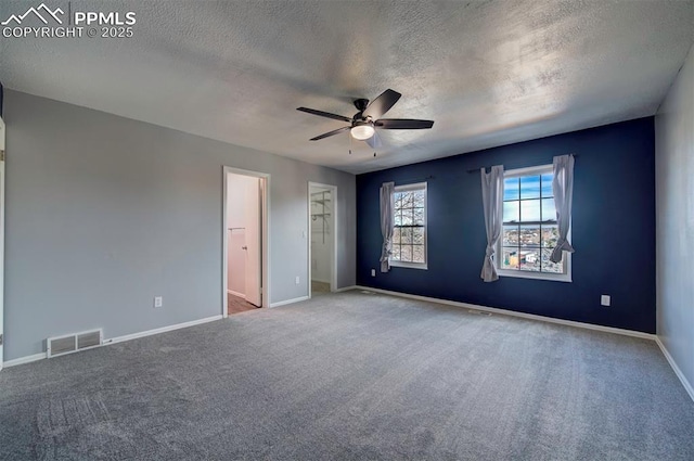 unfurnished bedroom featuring ceiling fan, carpet flooring, and a textured ceiling