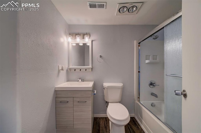 full bathroom with vanity, hardwood / wood-style floors, shower / bath combination with glass door, and toilet