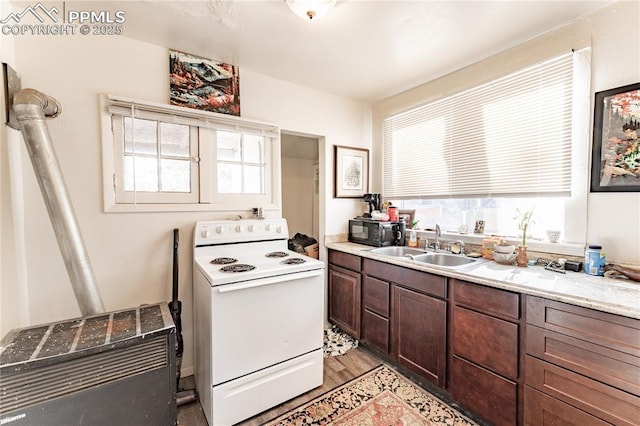 kitchen with white electric range oven, sink, dark brown cabinets, and a wealth of natural light