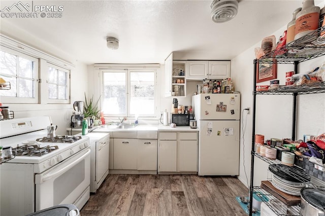 kitchen featuring white cabinetry, white appliances, and light hardwood / wood-style flooring