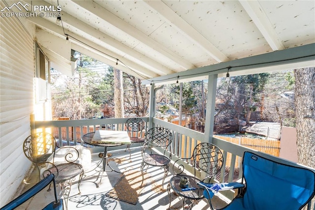 unfurnished sunroom with lofted ceiling with beams