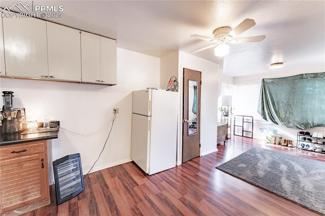 kitchen with white refrigerator, ceiling fan, dark hardwood / wood-style floors, and white cabinets