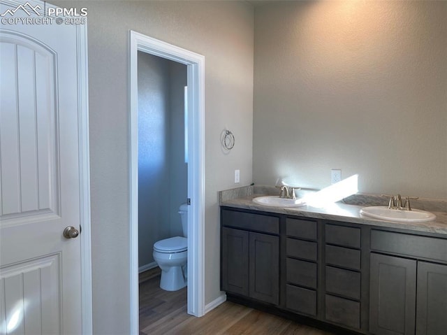 bathroom with vanity, wood-type flooring, and toilet