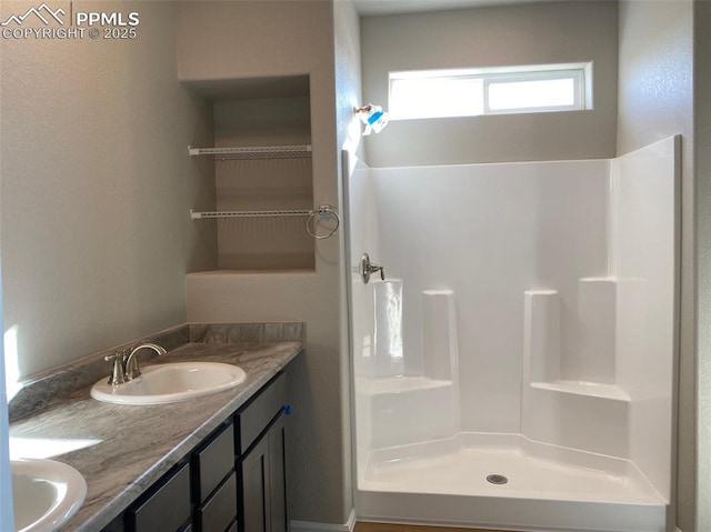 bathroom with walk in shower and vanity