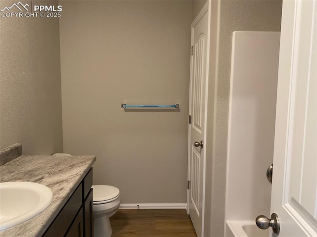 bathroom featuring hardwood / wood-style flooring, vanity, and toilet