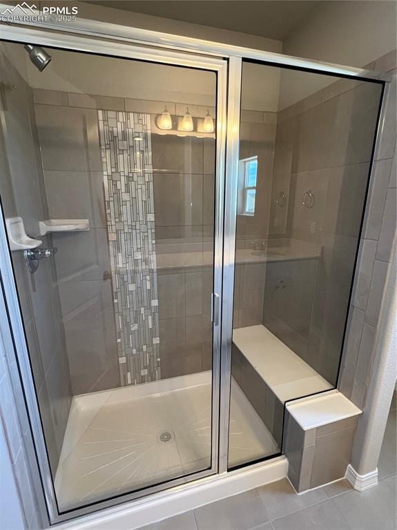 bathroom featuring a shower with shower door and tile patterned floors