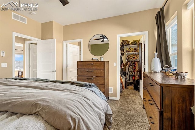 bedroom with light colored carpet, a closet, and a walk in closet