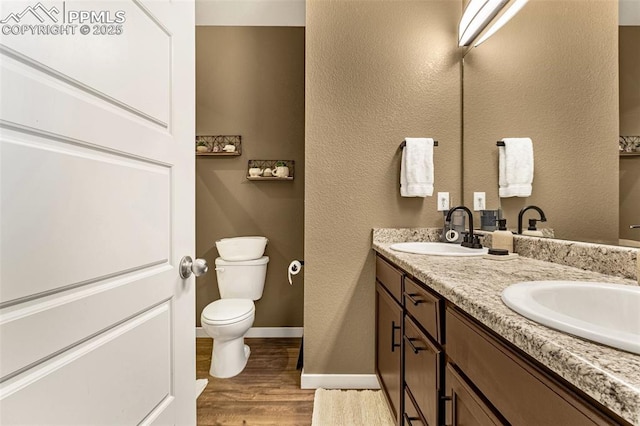 bathroom with hardwood / wood-style flooring, vanity, and toilet