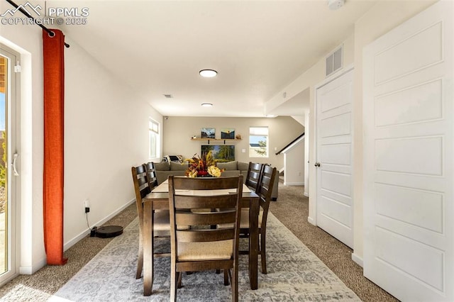 carpeted dining space featuring plenty of natural light