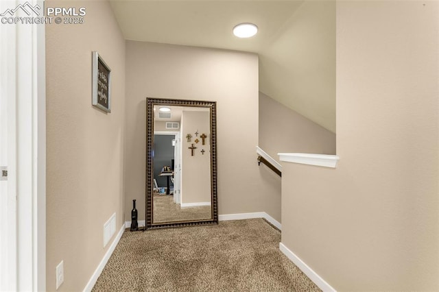 hall with lofted ceiling and carpet floors