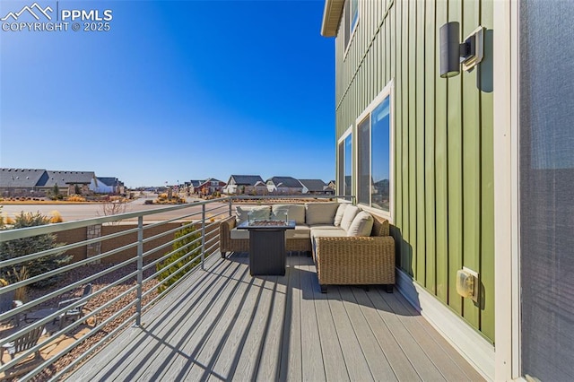 wooden terrace with an outdoor living space with a fire pit