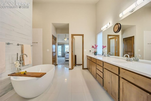 bathroom featuring vanity, a bathing tub, tile patterned flooring, and a high ceiling