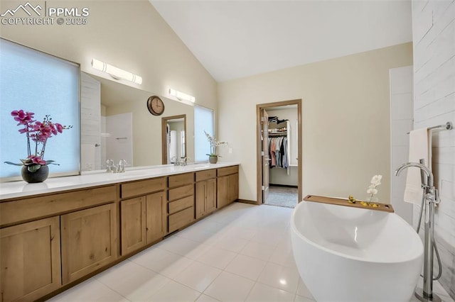 bathroom featuring lofted ceiling, a tub to relax in, and vanity