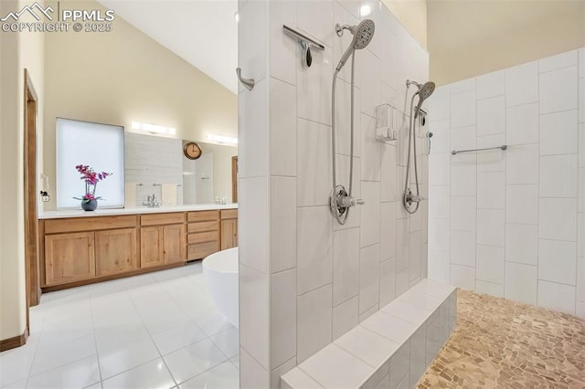 bathroom with lofted ceiling, vanity, tile patterned floors, and a tile shower