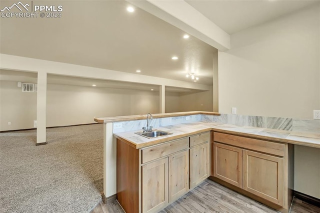 kitchen featuring kitchen peninsula, sink, and light brown cabinets