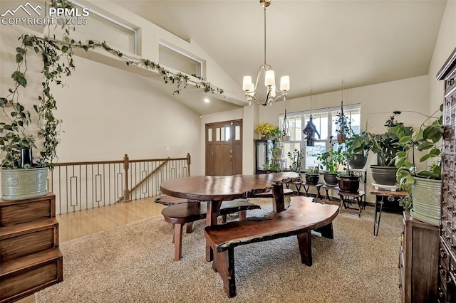 dining area featuring an inviting chandelier, lofted ceiling, and hardwood / wood-style floors