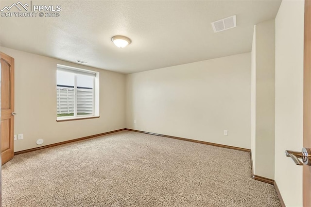 carpeted empty room with a textured ceiling