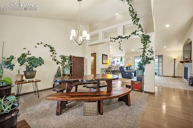 interior space with an inviting chandelier, a towering ceiling, and wood-type flooring