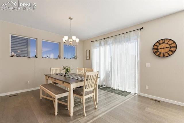 dining space featuring hardwood / wood-style flooring and a notable chandelier