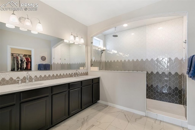 bathroom featuring vanity, tiled shower, and decorative backsplash