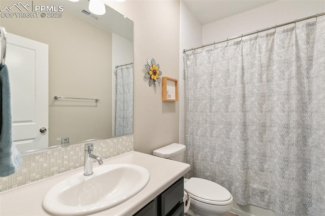 bathroom with tasteful backsplash, vanity, toilet, and walk in shower