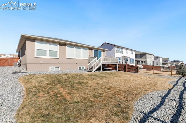 rear view of property with central AC unit, a lawn, and a deck