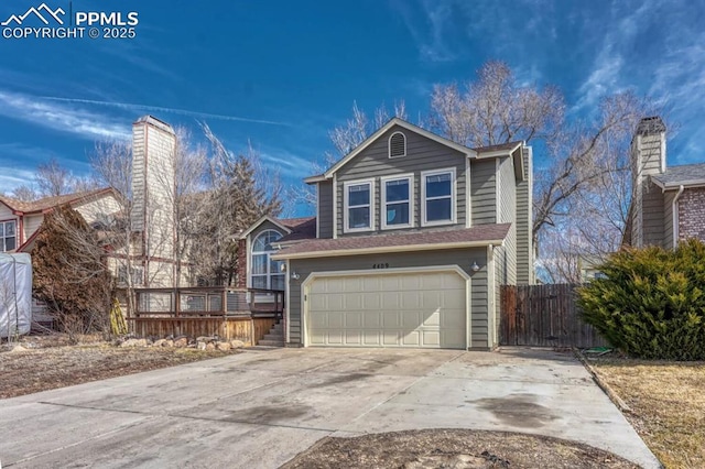 view of front facade featuring a garage, concrete driveway, and fence