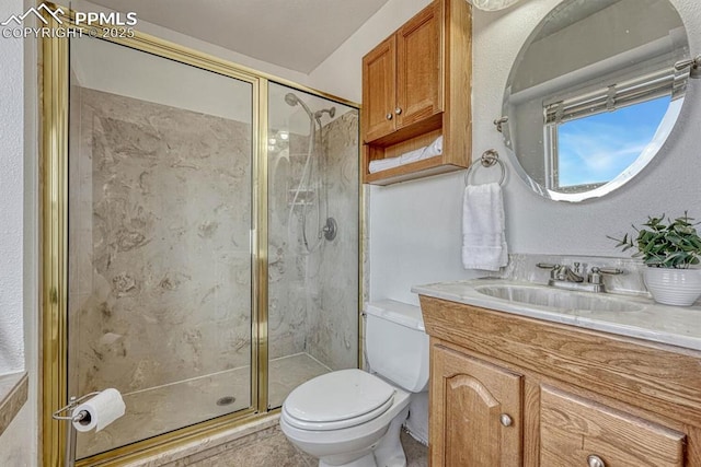 full bath featuring a marble finish shower, vanity, and toilet