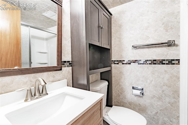 bathroom with vanity, tile walls, backsplash, and toilet