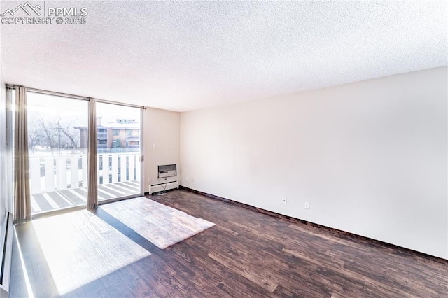 unfurnished room with floor to ceiling windows, dark hardwood / wood-style flooring, a textured ceiling, and a baseboard heating unit