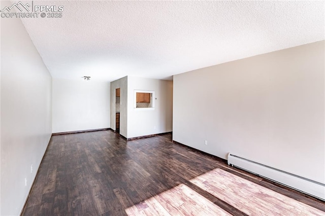 empty room with a baseboard radiator, dark hardwood / wood-style floors, and a textured ceiling