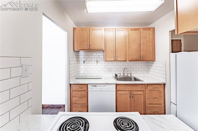 kitchen featuring light brown cabinetry, sink, white appliances, and decorative backsplash