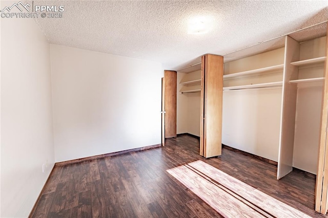 unfurnished bedroom with dark hardwood / wood-style flooring and a textured ceiling