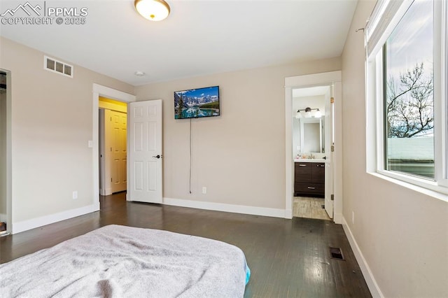 bedroom featuring dark wood-type flooring and ensuite bathroom