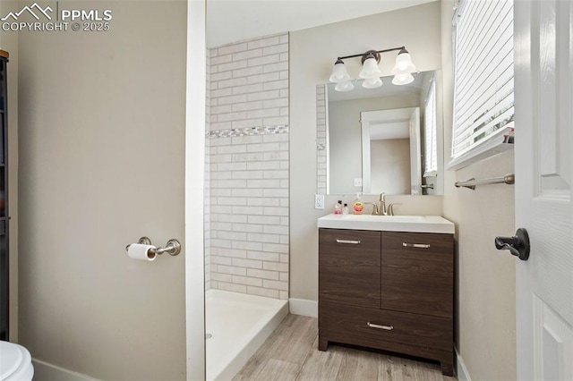 bathroom featuring vanity, wood-type flooring, and tiled shower